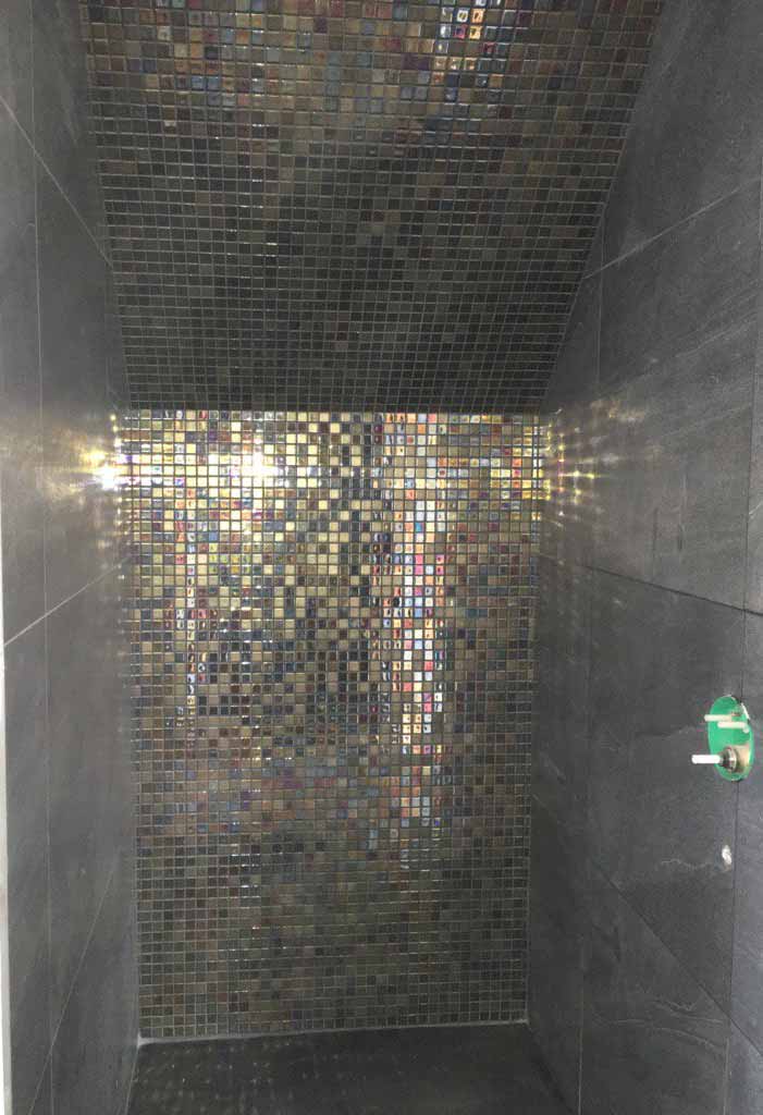 Ceramic copper mosaics on feature wall with dark sandstone effect wall tiles