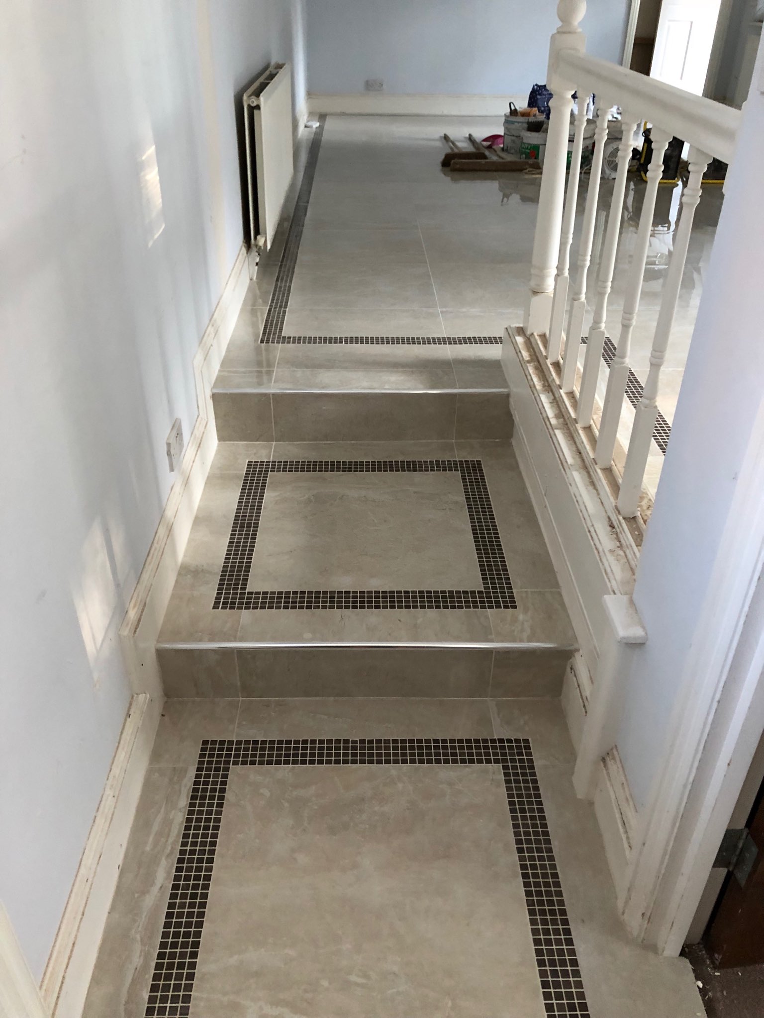 Hallway, steps and lounge with mosaic border