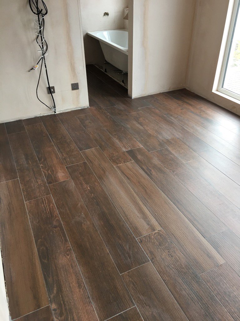 Wood effect tiles laid in a bedroom and ensuite